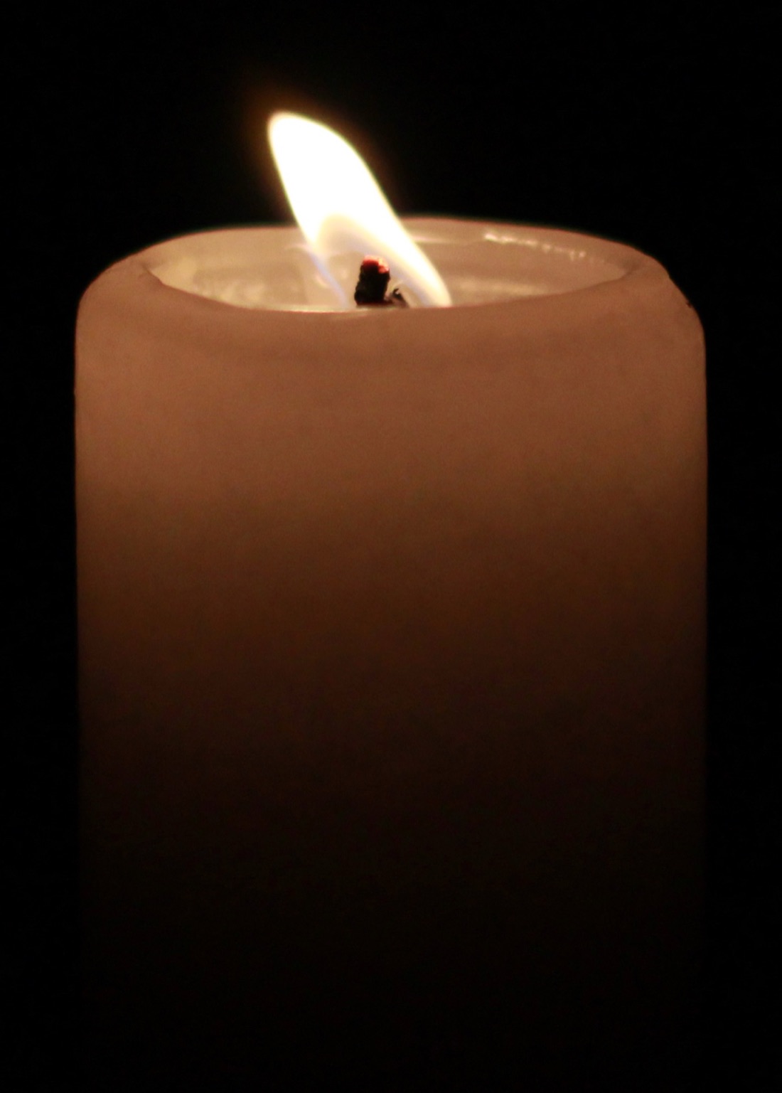 A single candle burning in the dark